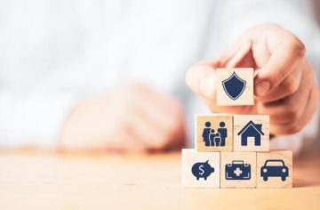 Businessman putting wooden cube block stacking with insurance and assurance icon including family health real estate car and financial for risk management concept photo