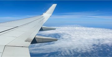 Wing od a plane soaring over clouds